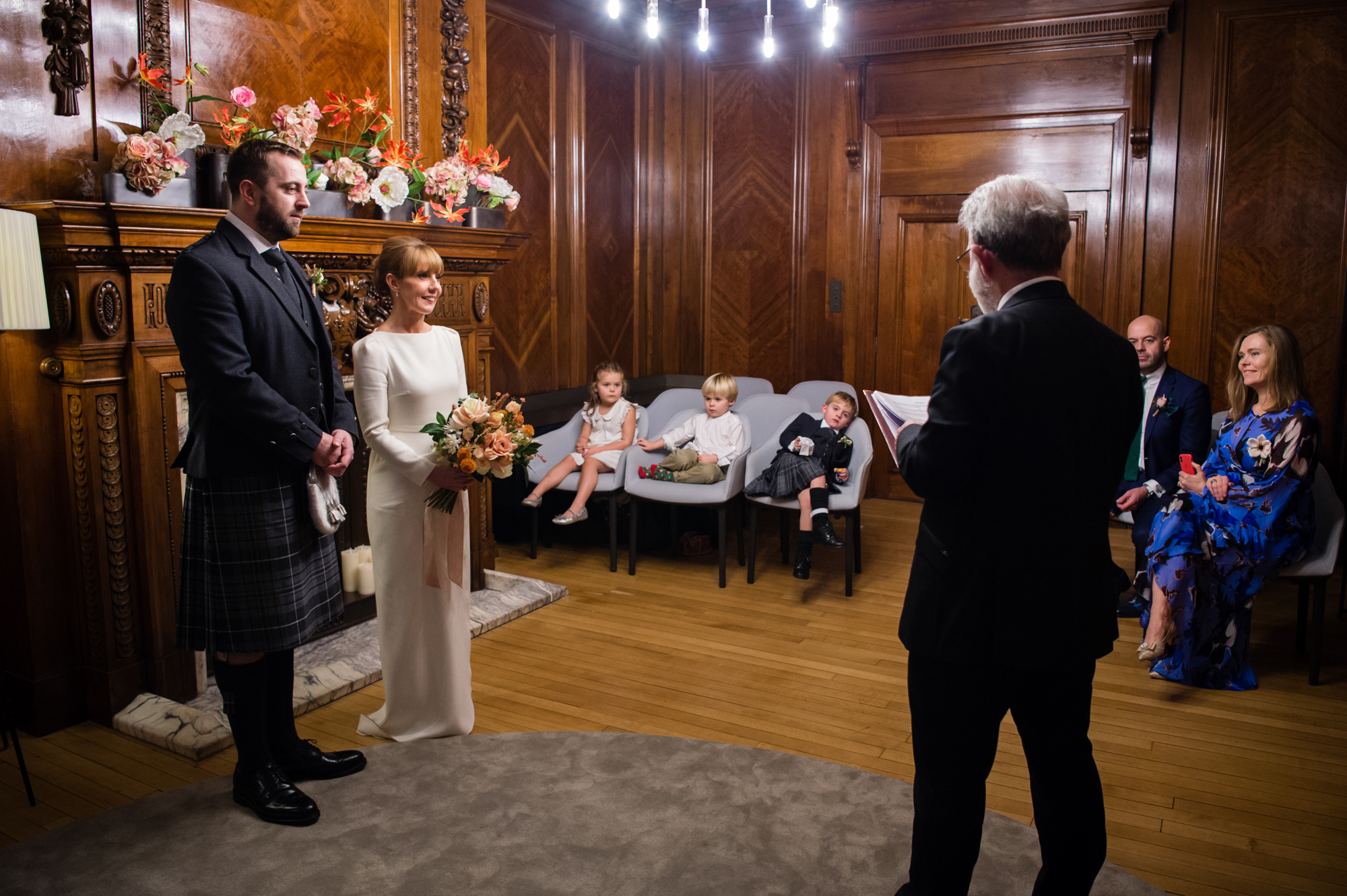 A bride and groom getting married in the Marylebone Room inside Marylebone Town Hall registry office